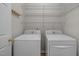 Functional laundry room includes washer, dryer, wire shelving, and coat hooks for added convenience at 215 Longbridge Dr, Cary, NC 27518