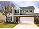 Two-story home boasting brick accents, green shutters, and a well-manicured lawn at 2344 Lazy River Dr, Raleigh, NC 27610