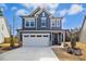 Charming two-story home with a two-car garage, blue siding, and manicured front yard at 2515 Maplemere Ct, Durham, NC 27703