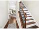 Elegant hallway featuring wood floors, staircase with iron spindles, and views into the dining area at 2515 Maplemere Ct, Durham, NC 27703