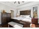 Sun-drenched main bedroom features dark wood accents, hardwood floors, and tray ceilings at 2515 Maplemere Ct, Durham, NC 27703