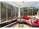 Cozy sunroom with wicker furniture, hardwood floors, and views of the lush green backyard at 2515 Maplemere Ct, Durham, NC 27703