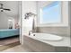 Elegant bathroom featuring a soaking tub, natural light, and views of bedroom at 285 Scotland Dr, Youngsville, NC 27596