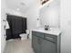 A clean bathroom with a dark shower curtain, grey vanity, and bright lighting at 285 Scotland Dr, Youngsville, NC 27596