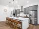Modern kitchen featuring gray cabinets, a large island with barstool seating, and stainless steel appliances at 285 Scotland Dr, Youngsville, NC 27596
