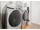 Modern laundry room featuring a large-capacity, front-load washer and dryer set, a wire rack, and a convenient vacuum at 285 Scotland Dr, Youngsville, NC 27596