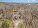 A high aerial view showcases the house nestled among mature trees at 3011 Little Creek Ln, Hillsborough, NC 27278