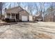 Exterior view of two houses, each with a front porch and garage, situated in a wooded lot at 3011 Little Creek Ln, Hillsborough, NC 27278