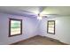 A bedroom with carpet and two windows for plenty of light at 323 Ranch Farm Rd, Raleigh, NC 27603
