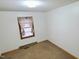 This carpeted bedroom is bright with white walls and a window at 323 Ranch Farm Rd, Raleigh, NC 27603