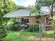 Brick house featuring a carport and fenced yard, providing convenience and security with mature greenery around the property at 323 Ranch Farm Rd, Raleigh, NC 27603