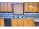 A kitchen featuring double sinks, ample counter space, and wooden cabinets at 323 Ranch Farm Rd, Raleigh, NC 27603