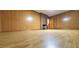 Spacious living room with hardwood floors, wood paneling, and a brick fireplace at 323 Ranch Farm Rd, Raleigh, NC 27603