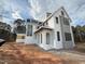 Striking white exterior with black trim and arched entry provides timeless appeal at 3321 Founding Place, Raleigh, NC 27612