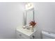 Clean half-bathroom with a decorative mirror, vanity, sink, and toilet at 3528 Dewing Dr, Raleigh, NC 27616