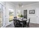 Cozy dining area with a modern chandelier, large windows, and seating for four at 3528 Dewing Dr, Raleigh, NC 27616