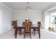 Bright dining room features wood table, chairs and modern chandelier at 3528 Dewing Dr, Raleigh, NC 27616