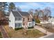 Elegant two-story home with a brick and siding facade, surrounded by mature trees and lush landscaping at 3528 Dewing Dr, Raleigh, NC 27616