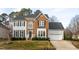 Traditional two-story brick and siding home with well-manicured landscaping and a two-car garage at 3528 Dewing Dr, Raleigh, NC 27616