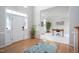 Bright foyer with hardwood floors, a patterned rug, and view to an office with a large desk at 3528 Dewing Dr, Raleigh, NC 27616
