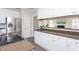 Modern kitchen with stainless steel refrigerator, white cabinets, and warm countertops at 3528 Dewing Dr, Raleigh, NC 27616