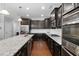 Modern kitchen featuring granite countertops, dark cabinets, and stainless steel appliances at 357 Roberts Ridge Dr, Cary, NC 27513