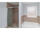 Bright bathroom showcasing a shower with glass door, with a tiled backsplash and a bathtub at 388 Holland Dr, Smithfield, NC 27577