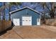 A spacious detached two-car garage boasts a blue exterior, with a white roll-up door, and a fenced-in yard at 388 Holland Dr, Smithfield, NC 27577