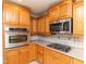 Warm and inviting eat-in kitchen featuring a stainless steel wall oven and cooktop with solid wood cabinets at 388 Holland Dr, Smithfield, NC 27577