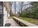 View of the back deck with a wooden bench overlooking the spacious backyard with mature trees and green grass at 4812 Stonehill Dr, Raleigh, NC 27609