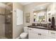 Bright bathroom featuring a glass shower, vanity, and a large mirror at 4812 Stonehill Dr, Raleigh, NC 27609