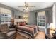 Comfortable bedroom featuring a ceiling fan, a chair, and two bright windows at 4812 Stonehill Dr, Raleigh, NC 27609