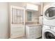 Bright laundry room with white cabinetry, washer, dryer, and convenient door to the outside at 4812 Stonehill Dr, Raleigh, NC 27609