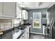 Charming kitchen features white cabinets, black appliances, granite countertops, and wood style flooring at 4901 North Pointe, Sanford, NC 27332