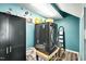 Laundry room with a dark washer-dryer, storage cabinet and painted turquoise walls at 4901 North Pointe, Sanford, NC 27332
