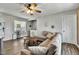 Comfortable living room featuring a plush sectional sofa, ceiling fan, and sunburst mirror on a light gray wall at 4901 North Pointe, Sanford, NC 27332