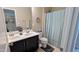 Well-lit bathroom with double sinks, and blue shower curtain offering a fresh, appealing aesthetic at 508 Stapleford Ln, Fuquay Varina, NC 27526