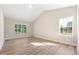 Bright bedroom with ample natural light, neutral paint, vaulted ceilings, and wood-look flooring at 5389 Salem Woods Dr # 12, Graham, NC 27253