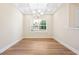 Bright dining area with wood floors, white trim, a modern chandelier, and large windows at 5389 Salem Woods Dr # 12, Graham, NC 27253