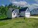 Beautifully landscaped home exterior featuring a two-car garage, light blue shingles, and inviting curb appeal at 5389 Salem Woods Dr # 12, Graham, NC 27253