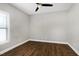 This bedroom boasts a ceiling fan, neutral walls, and dark wood floors at 5439 Cokesbury Rd, Fuquay Varina, NC 27526