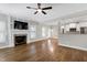Open-concept living room featuring a fireplace with stone accents and hardwood floors at 5439 Cokesbury Rd, Fuquay Varina, NC 27526