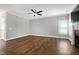 The large, well-lit living room boasts beautiful hardwood floors, a modern ceiling fan, and a corner fireplace at 5439 Cokesbury Rd, Fuquay Varina, NC 27526