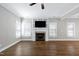 The living room has a fireplace and large windows, is well-lit, and has a ceiling fan at 5439 Cokesbury Rd, Fuquay Varina, NC 27526