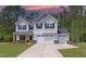 Two-story home with a three-car garage, blue shutters, and a well-manicured lawn against a backdrop of lush green trees at 6800 Franklin Heights Rd, Cary, NC 27518