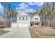 Two-story home with gray siding, stone accents, three-car garage, and landscaping with green trees surrounding the property at 6800 Franklin Heights Rd, Cary, NC 27518