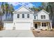 Two-story home with gray siding, stone accents, three-car garage, landscaping, and a 'For Sale' sign at 6800 Franklin Heights Rd, Cary, NC 27518
