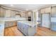Bright eat-in kitchen featuring stainless appliances, a large granite island, and light wood floors at 6800 Franklin Heights Rd, Cary, NC 27518