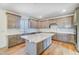 Well-lit kitchen with stainless appliances, a large granite island, and ample cabinet space at 6800 Franklin Heights Rd, Cary, NC 27518