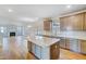 Island kitchen opens into the dining and living areas with seamless flow and light wood floors at 6800 Franklin Heights Rd, Cary, NC 27518